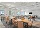 Bright dining room features neutral decor, modern chandeliers, and large windows with views of the community's tropical landscaping at 10121 Beachwalk Dr, Englewood, FL 34223