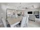 Bright dining area featuring a chandelier, a modern table set, and open access to the kitchen at 10121 Beachwalk Dr, Englewood, FL 34223