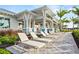 Exterior view of the clubhouse with lounge chairs, covered area, and manicured landscaping at 10121 Beachwalk Dr, Englewood, FL 34223
