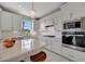 Spacious modern kitchen featuring a center island, white cabinets, and stainless steel appliances at 10121 Beachwalk Dr, Englewood, FL 34223