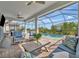 Inviting screened-in lanai with outdoor seating area overlooking a sparkling swimming pool at 10121 Beachwalk Dr, Englewood, FL 34223