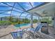 Relaxing poolside lounge area with comfortable seating, an outdoor grill, and lush green landscaping at 10121 Beachwalk Dr, Englewood, FL 34223