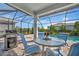 Stylish pool area with an outdoor kitchen, dining set, and views of a sparkling pool at 10121 Beachwalk Dr, Englewood, FL 34223