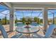 Relaxing view of a swimming pool from a shady lanai, framed by a clock and comfortable seating at 10121 Beachwalk Dr, Englewood, FL 34223