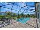 Screened-in pool area featuring a beautiful in-ground pool and outdoor seating at 10121 Beachwalk Dr, Englewood, FL 34223