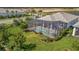 Aerial view of screened-in pool with ample patio space for outdoor dining and relaxation surrounded by landscaping at 10121 Beachwalk Dr, Englewood, FL 34223