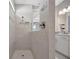 Bathroom with a glass door shower featuring modern tile and fixtures at 10121 Beachwalk Dr, Englewood, FL 34223