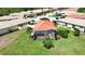 A single-Gathering home with a red tile roof and screened-in lanai surrounded by palm trees at 102 Mestre Pl, North Venice, FL 34275