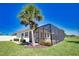 A lovely backyard shows a screen enclosed porch with a palm tree, and manicured lawn at 102 Mestre Pl, North Venice, FL 34275