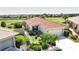 Aerial view of a charming home featuring lush landscaping, red roof, and attached garage at 102 Mestre Pl, North Venice, FL 34275
