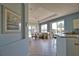 Open-concept living space featuring a kitchen with breakfast bar flowing into the living area with natural light at 102 Mestre Pl, North Venice, FL 34275