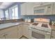 Well-equipped kitchen featuring white cabinets, a microwave, and a gas range at 102 Mestre Pl, North Venice, FL 34275