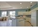Bright and airy kitchen with white cabinetry, tiled floors, and a breakfast bar overlooking the living area at 102 Mestre Pl, North Venice, FL 34275