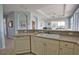 Bright kitchen with a double sink, tile floors, and a view into the living area at 102 Mestre Pl, North Venice, FL 34275