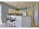 Bright kitchen featuring a breakfast bar with seating, white cabinets, and stainless steel appliances at 102 Mestre Pl, North Venice, FL 34275