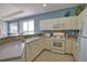 Charming kitchen featuring white cabinetry, tile floors, and modern appliances at 102 Mestre Pl, North Venice, FL 34275