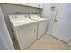 Laundry room featuring a washer, dryer, and tile floors at 102 Mestre Pl, North Venice, FL 34275