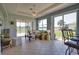 Cozy living room with tile floors, ceiling fan, and sliding glass doors to the lanai at 102 Mestre Pl, North Venice, FL 34275
