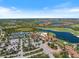 Community aerial view featuring tennis courts, large pool, lush landscaping, golf course, and lakes at 10209 Fiddlewood Dr, Venice, FL 34293