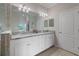 Bathroom featuring double sinks, granite countertop and white cabinetry at 10209 Fiddlewood Dr, Venice, FL 34293