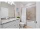Well-lit bathroom featuring a granite countertop and tub with shower at 10209 Fiddlewood Dr, Venice, FL 34293