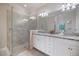 Bathroom featuring dual sinks, granite counters, and a glass-enclosed shower at 10209 Fiddlewood Dr, Venice, FL 34293