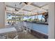 The clubhouse bar features a relaxed ambiance, with ceiling fans, a stone floor, and a bar with white seating at 10209 Fiddlewood Dr, Venice, FL 34293