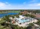 Resort-style community pool with palm trees, lounge chairs, and beautiful lake views at 10209 Fiddlewood Dr, Venice, FL 34293