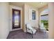 Inviting front porch with brick flooring, seating, and decorative window shutters at 10209 Fiddlewood Dr, Venice, FL 34293