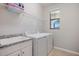 Well-equipped laundry room includes a utility sink, washer, dryer, and ample shelving at 10209 Fiddlewood Dr, Venice, FL 34293
