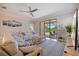 Cozy living room with couches, rug, and view of the screened-in pool area at 10209 Fiddlewood Dr, Venice, FL 34293