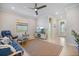 Bright living room featuring tile floors, ceiling fan, and a comfortable blue sofa at 10209 Fiddlewood Dr, Venice, FL 34293