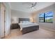 Well-lit bedroom with a cozy king bed, ceiling fan and view of the screened lanai at 10209 Fiddlewood Dr, Venice, FL 34293