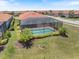 Backyard view of the screened-in pool and patio, surrounded by manicured landscaping at 10209 Fiddlewood Dr, Venice, FL 34293
