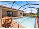 Relaxing screened pool area with brick pavers and outside dining set, perfect for enjoying Florida weather at 10209 Fiddlewood Dr, Venice, FL 34293