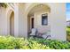 Inviting covered porch with comfortable seating, surrounded by lush, green landscaping at 10209 Fiddlewood Dr, Venice, FL 34293