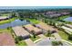 Aerial view of houses with tile roofs and a scenic pond, contributing to the neighborhood's pleasant ambiance at 10410 Inglenook Ter, Palmetto, FL 34221