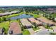 Aerial view of houses with tile roofs and a scenic pond, creating an attractive neighborhood atmosphere at 10410 Inglenook Ter, Palmetto, FL 34221
