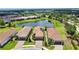 An aerial view displays houses with tile roofs and a scenic pond, increasing the charm of the neighborhood at 10410 Inglenook Ter, Palmetto, FL 34221