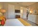 Well-lit bedroom with plush carpet, white dresser, and doorway leading to ensuite bathroom at 10410 Inglenook Ter, Palmetto, FL 34221