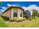 Back exterior showcasing a screened-in lanai, lush lawn, and decorative landscaping at 10410 Inglenook Ter, Palmetto, FL 34221