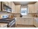 Updated kitchen showcasing stainless steel gas range, modern microwave, and white cabinetry with ample storage space at 10410 Inglenook Ter, Palmetto, FL 34221