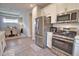 Open kitchen with stainless steel refrigerator and range leading to the bright dining area, ideal for Gathering meals at 10410 Inglenook Ter, Palmetto, FL 34221