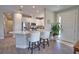 Bright open kitchen with white cabinets, stainless appliances, and a long center island with bar stool seating at 10410 Inglenook Ter, Palmetto, FL 34221