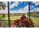 Serene screened lanai offering a stunning view of the picturesque lake and lush greenery at 10410 Inglenook Ter, Palmetto, FL 34221