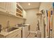 Well-equipped laundry room features a utility sink, washer, dryer, white cabinets, and ample storage space at 10410 Inglenook Ter, Palmetto, FL 34221