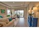 Cozy living room with modern decor, tray ceilings, neutral walls, tile floors, and sliding glass doors at 10410 Inglenook Ter, Palmetto, FL 34221