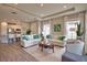 Spacious living room with modern decor, tile floors, neutral walls, tray ceiling, and comfortable seating at 10410 Inglenook Ter, Palmetto, FL 34221