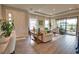 Spacious living room with tile floors, neutral walls, tray ceiling, large windows, and comfortable seating at 10410 Inglenook Ter, Palmetto, FL 34221