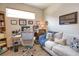 Bright home office features a comfortable sofa, desk, and wood-look tile flooring at 10410 Inglenook Ter, Palmetto, FL 34221